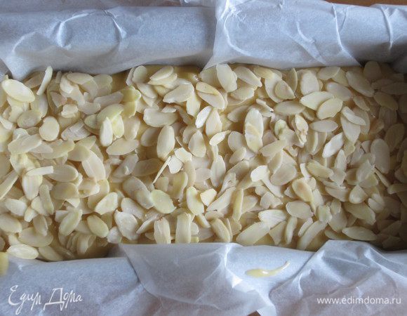 Выложить тесто в форму с пергаментом,посыпать миндальными лепестками и выпекать в разогретой до 180°С духовке 35-40 минут.