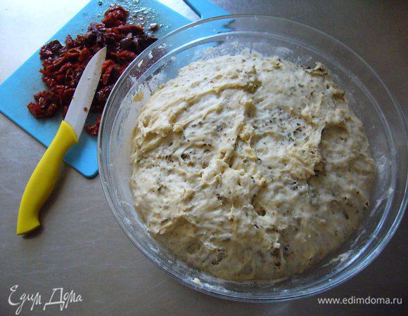 В подросшее тесто выкладываем томаты, вымешиваем.