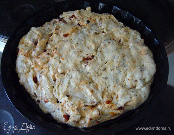 В смазанную маслом круглую форму выкладываем получившееся тесто и оставляем на 15-20 минут. Томаты и оливки лучше вдавить в тесто, чтобы при выпекании они не подгорели.