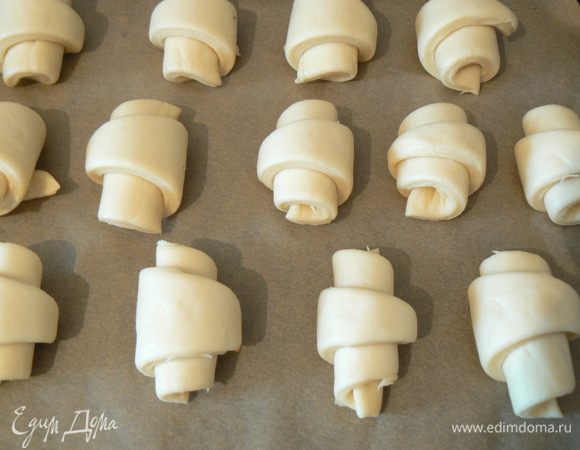 Выложить  булочки на противень и оставить на 30 минут .
Смазать желтком и запекать в разогретой до 180-200С духовке до готовности, около 30-35 минут.
