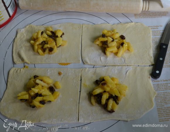 Слоеное тесто выложить на поверхность с мукой,раскатать слегка и разрезать на 4 части. Желательно на красивые квадраты. У меня без идеальных форм.
Выложить на каждый квадрат начинку в центр, ровно поделив на 4 квадрата.