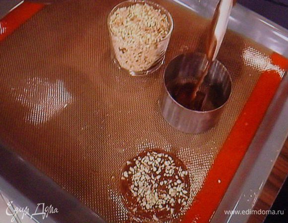 Духовку разогреть до 180°. Тесто выложить при  помощи лопатки и кулинарных  кружков, тонким слоем на застеленый пекарской бумагой противень. Так кружки получаются ровными и одинаковыми в диаметре. Каждый коржик посыпать дроблёным фундуком.