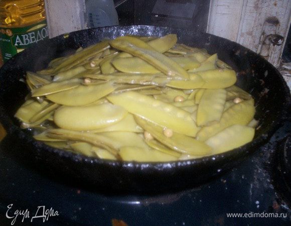 На сковороду к луку пересыпаем вареный горох. Тушим под закрытой крышкой время от времени помешивая на среднем огне.