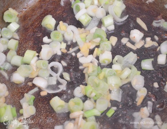 вновь наливаем в вок масло, обжариваем на нем имбирь, чеснок и белый лук 30 секунд 