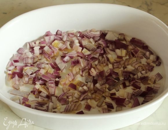 Форму для запекания слегка смазать оливковым маслом и выложить в нее лук.