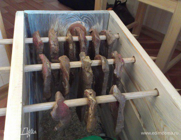 ... и вешаем его в специально подготовленный коробок для вяления. Обязательно чтобы куски мяса не касались друг друга и чтобы в коробке была лёгкая вентиляция. Я такой сколотил из сосновых досок, и настрогал палочек из дуба, на полу коробка сосновые стружки (ибо дерево даёт неповторимый вкус). Каждый определяет для себя степень готовности Билтонга сам, я например люблю посуше, поэтому я жду от 10 до 15 дней.
ПРИЯТНОГО АППЕТИТА !!!