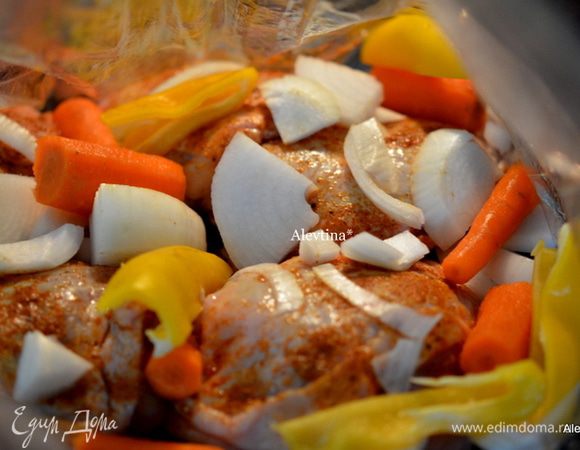 Добавить куриные бедрышки и овощи в пакет.
 Пакет закроем и сделаем 4 маленькие дырочки. Пакет положим на противень и отправим в духовку на 1 час.