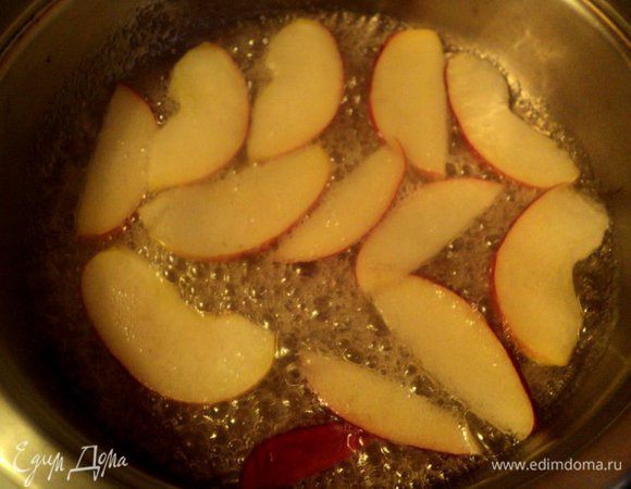 Украсить торт розами из яблок. Яблоки разрезать на четвертинки, убрать семена и порезать тонкими пластинками. Высыпать на сковородку сахар, добавить 40 мл воды, немного лимонного сока и сварить сироп. Выложить пластинки яблок и проварить по 20 секунд  с двух сторон. Выложить на тарелку, охладить.