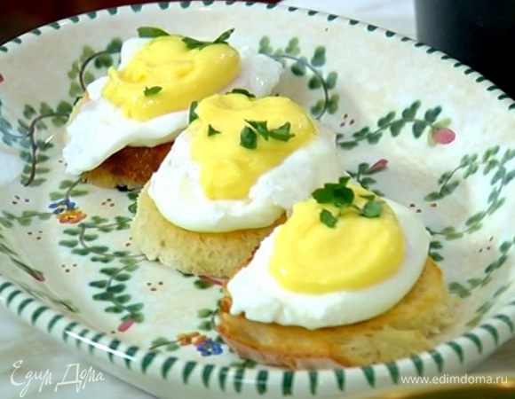 На гренки поместить яйца пашот, а сверху выложить соус. Украсить листьями петрушки.