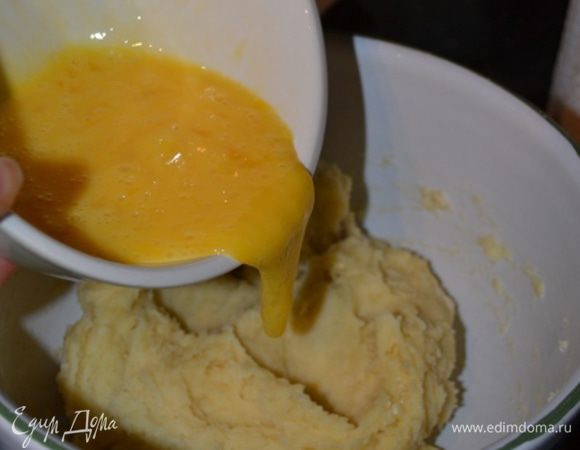 В отдельной посуде быстренько разбить и размешать яйца в омлет. Залить их в тесто, тщательно мешая деревянной ложкой. Сначала яйца не захотят вмешиваться, но через пару минут у вас получится гладкое тесто, которое легко мешать.