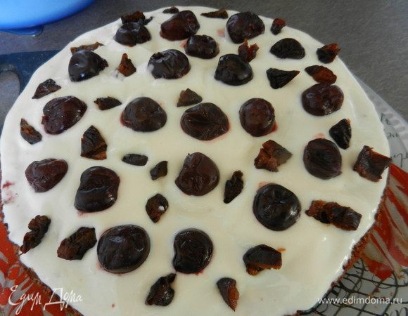 Пропитать готовые коржи соком вишни, смазать кремом, посыпать вишней и черносливом. Верхний слой смазываем кремом и украшаем тем, что есть под рукой. Можно натереть шоколад на крупной терке, а можно смешать орехи с медом.