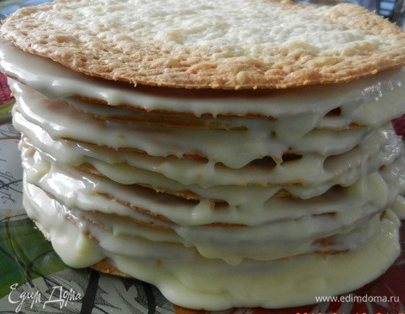 Собирать торт просто. На красивое блюдо в центре поместите 1 ст. л. крема, потом первый корж. Его покрыть слоем крема. Далее следующий корж, чуть-чуть придавить и нанести крем, и т.д., пока не выложите горку из 12 коржей. Нанесите крем по бокам торта и сверху и поставьте на ночь в холодильник вместе с излишками крема.