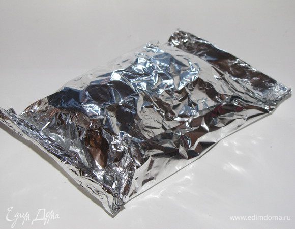 Сложите длинные стороны фольи вместе и заверните так, как вы заворачиваете бутерброд. Концы плотно закрутите, чтобы масло при жарке не вытекло.