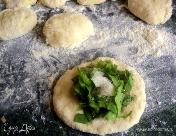 Тесто разделать на небольшие кусочки, примять в лепешку. Положить на середину щавель, сверху насыпать неполную чайную ложку сахара, защипнуть.