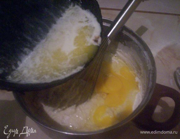 Растапливаем на медленном огне масло. Я это делаю в той же сковородке, в которой потом собираюсь выпекать блины. 
К полученной выше смеси добавляем растопленное масло и вбиваем яйца. Хорошо перемешиваем венчиком.