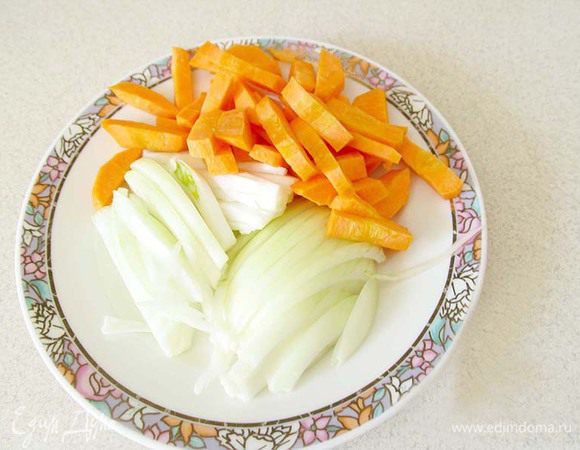 Лук нарежьте полукольцами, морковь — брусочками. Морковь в этом блюде использовать необязательно, все по желанию. Добавьте морковь с луком к мясу и жарьте до мягкости моркови.