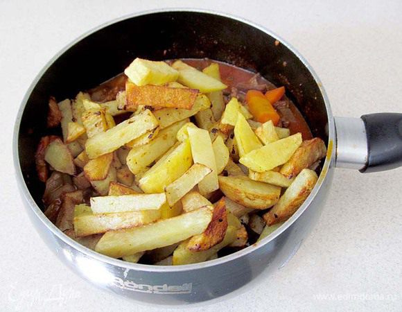 Теперь нужно соединить поджаренный картофель и измельченный чеснок с подливой. Если нет молодого чеснока, то просто измельчите 2 зубчика обычного. Прогрейте 5 минут, посыпьте зеленью. Можно подавать. Приятного аппетита!