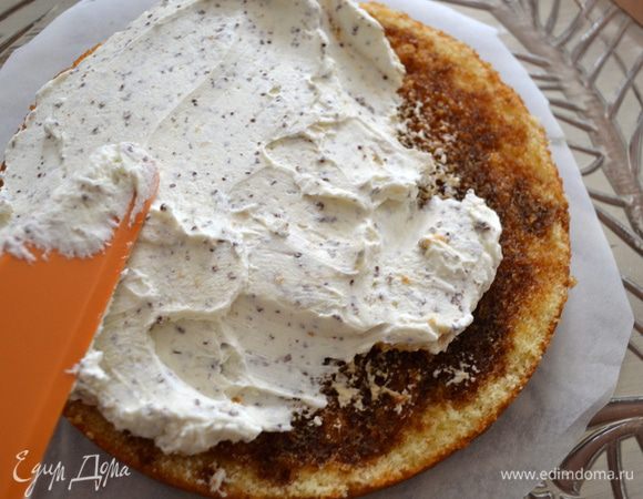 Крем зрительно поделить на две части. Нанести половину крема на первый корж.