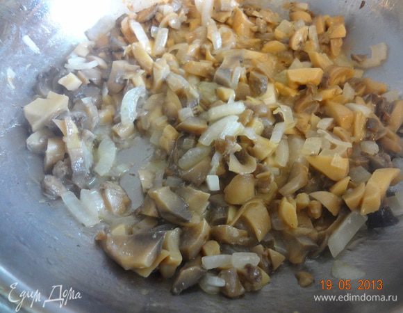 На другой сковороде разогреть растительное масло, добавить сливочное и обжарить лук до мягкости, затем добавить мелко порезанные грибы, все вместе обжарить до золотистого цвета.