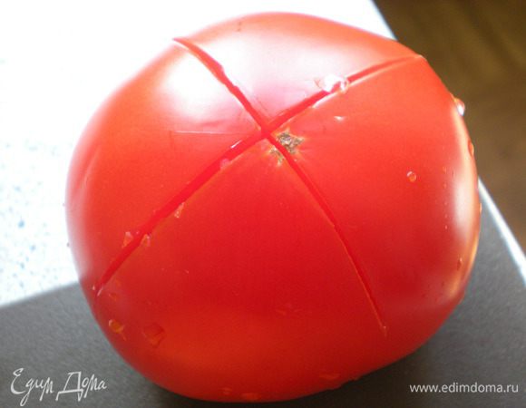 Помидоры надрезать крест-накрест. Бланшировать (*бланширование — кратковременная обработка продукта кипятком или паром), затем очистить. 