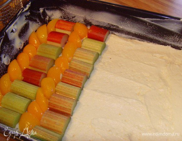 Тесто равномерно распределить по форме. Ревень и абрикосы уложить плотно рядами, порядок произвольный, но фрукта должна быть расположена вплотную. 