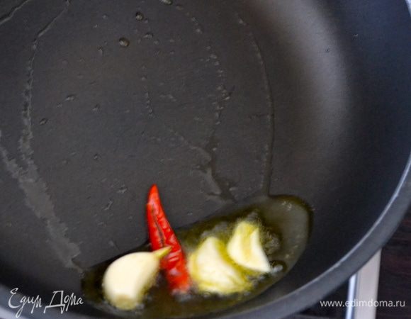 Воду, в которой варился осьминог процедить и поставить закипать... Как только закипит, положить отвариваться спагетти. А тем временем, на сковороде в оливковом масле обжарить чеснок и острый красный перец. Следите, чтобы чеснок ни в коем случае не пригорел!   