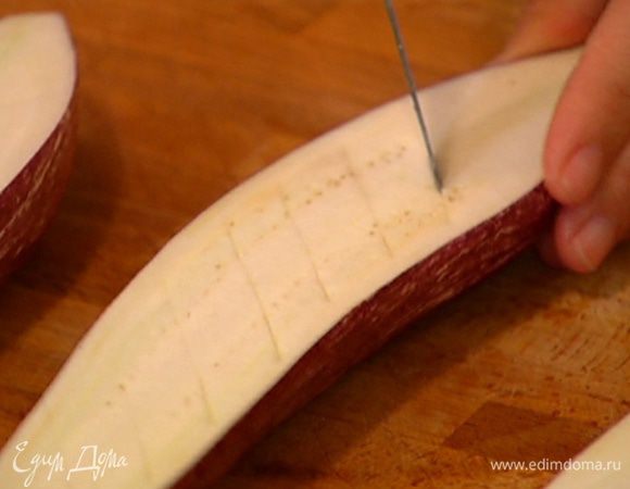 Баклажаны вместе с плодоножкой разрезать пополам вдоль и сделать диагональные крестообразные надрезы, стараясь не прорезать кожицу.