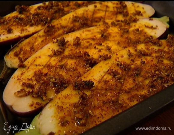 Баклажаны выложить в небольшой противень срезами вверх. Натереть их пряной заправкой (по 1 ч. ложке на каждую половинку баклажана) и запекать в разогретой духовке до готовности, 20–25 минут.