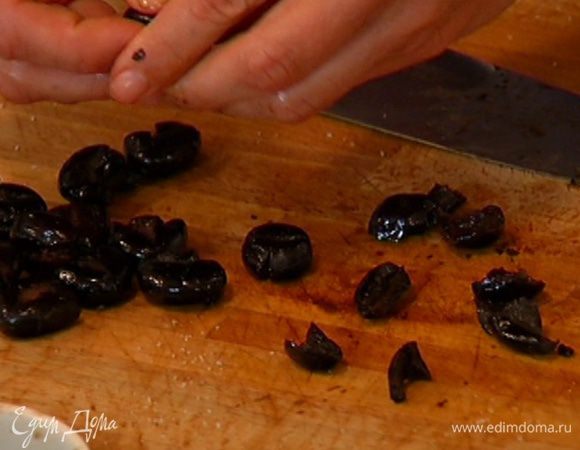Оливки раздавить плоской стороной ножа и удалить косточки.