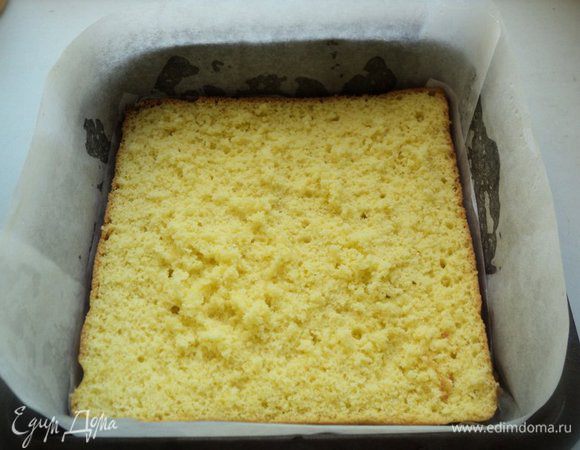 Бока формы обложить бумагой для выпечки. На дно положить один пласт бисквита.