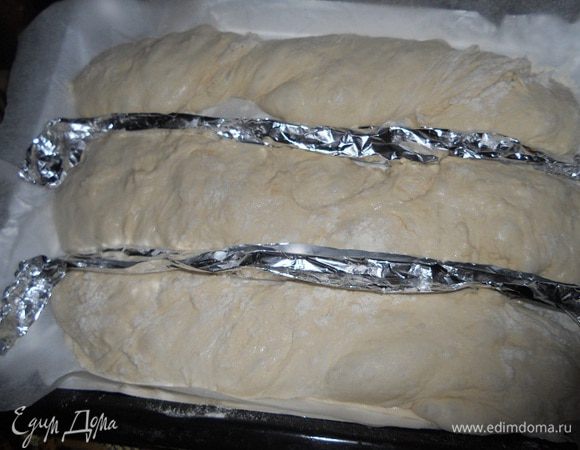Для багетов конечно в идеале иметь специальные формы, но я вышла с этого положения, свернула в несколько раз кусок фольги и разделила их таким образом.
Теперь припыляя тесто мукой делим его на багеты, и складываем на противень, застеленный бумагой для выпечки, разделяя фольгой и оставляем на минут 40 - 50 на расстойку.