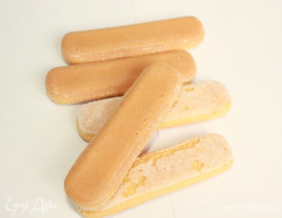 Заварите крепкий кофе, добавив в него апельсиновый сок и ликёр. Обмакивайте в эту смесь бисквитное печенье и уложите в прямоугольную форму. Сверху выложите крем. Повторите слои, завершив кремом. 