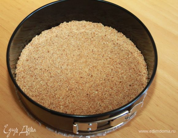 Выложить полученное тесто в 24 см форму и с помощью пальцев прижать смесь к поверхности формы. Поместить в холодильник, пока корж не станет твердым на ощупь (примерно полчаса).  