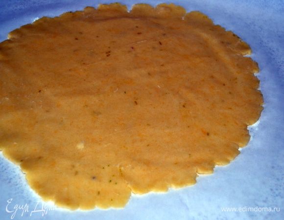 Меньший кусок теста раскатать на бумаге в круг.