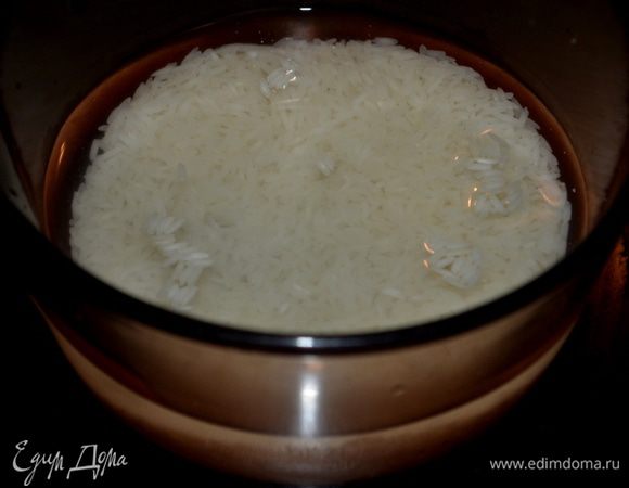 Тем временем всыпать рис в широкую кастрюлю с толстым дном, залить холодной водой так, чтобы она покрыла рис на 1 см. Поставить на огонь, довести до кипения, перемешать. Варить без крышки на слабом огне 5 мин., затем накрыть и готовить еще 15 мин. Снять с огня, оставить под крышкой на 5 мин., остудить. 