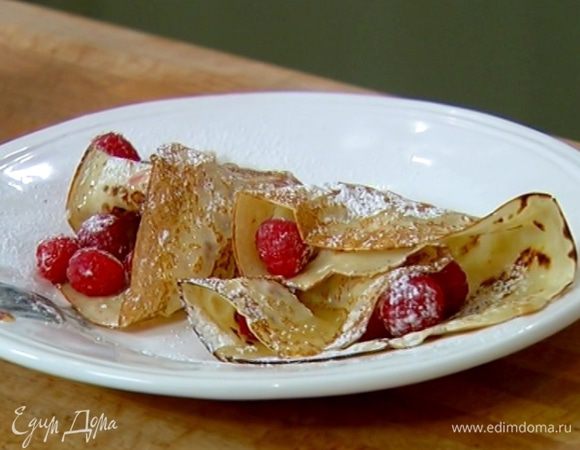 На каждый блин выложить горсть малины, слегка посыпать сахарной пудрой и свернуть треугольником, сверху полить жидким медом и посыпать сахарной пудрой.