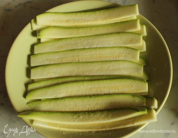 Выложить в тарелку и слегка посыпать солью. Кабачки дадут сок и ломтики станут более пластичными.