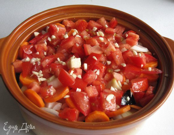 Сверху выложить половину нарезанных помидоров и половину чеснока. Посолить, влить бульон. 