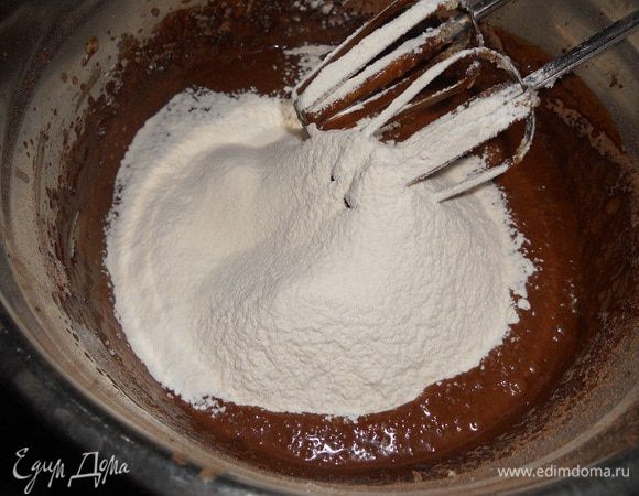 Добавить муку и перемешать до однородности. Тесто выкласть в форму и разровнять.