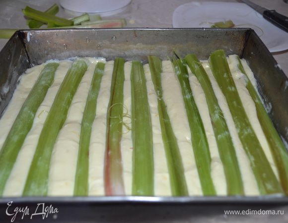 Выкладываем творожную начинку. Сверху по ширине формы выкладываем ревень, немного вдавливая его в начинку.