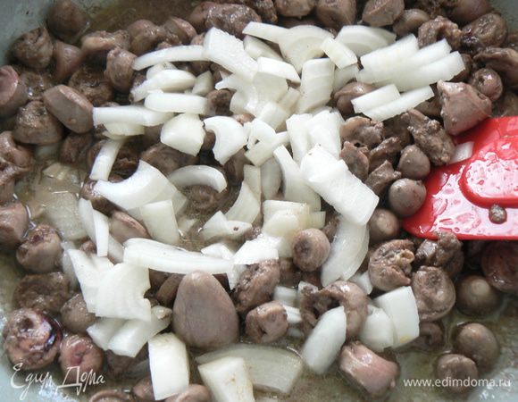 На растительном масле обжарить очищенные и порезанные сердечки, добавить лук.
