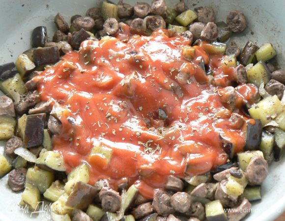 Тушить до готовности, заливаем протертыми помидорами, затем добавляем орегано, соль, черный перец. Снимаем с огня.