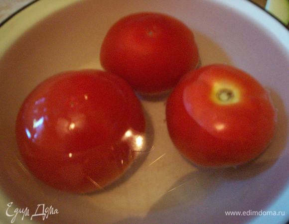 Снимаем с помидоров шкурку. Для того, чтобы сделать это быстро и легко, обдаем их крутым кипятком и оставляем в воде на полминуты - после такой тепловой обработки шкурка слезает очень легко. Режем помидоры на дольки.