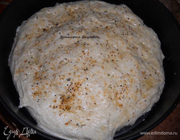 Тесто распределить по форме в виде лепешки, у меня разъемная форма 26,5 см в диаметре, верх теста немного попридавливать руками, сделать небольшие углубления, поверхность смазать 2 ст. л. масла и посыпать пряностями - розмарином, французской горчицей, помеленными вялеными томатами, оставить на подход, чтобы тесто увеличилось втрое, у меня на это ушло 1 час 20 минут.