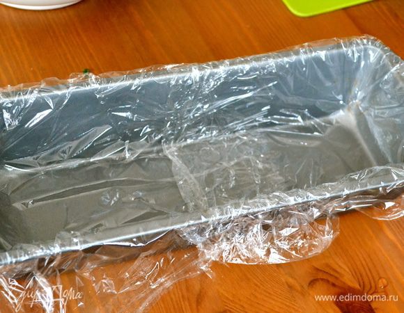 Прямоугольную форму для кекса застелить пищевой пленкой.