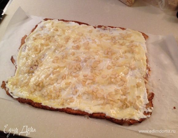 Хорошо взбить сливки. Намазать ими меренгу, далее намазать слой лимонного курда и посыпать миндальными хлопьями. С помощью бумаги, на которой лежит меренге, осторожно свернуть рулет.  