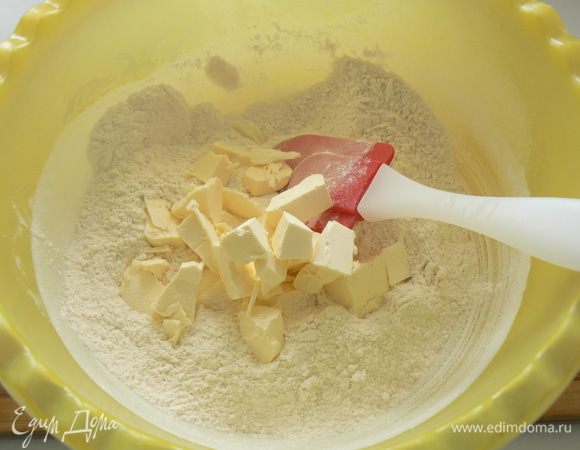 Приготовить тесто.
В миску просеять муку, добавить сахар, соль, разрыхлитель, тщательно перемешать. Хорошо охлаждённое масло нарезать на кусочки. 
