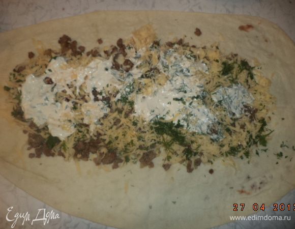 Лаваш развернуть. Выложить на него ровным слоем половину фарша. Сверху выложить помидоры, сыр, нарезанную зелень. 