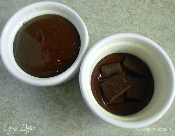 Смазать маслом и присыпать мукой формочки для выпекания. Заполнить их тестом на 1/3, положить кусочки  шоколада, а затем добавить остальное .Следите, чтобы кусочки шоколада не прикасались к стенкам формочек. (Теста хватило на 2 больших рамекина и 1 маленький)