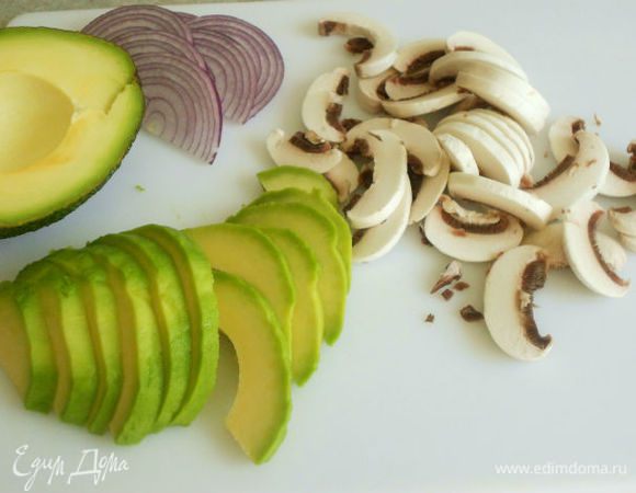 Шампиньоны и авокадо очистить и нарезать ломтиками. Луковицу нарезать полукольцами.